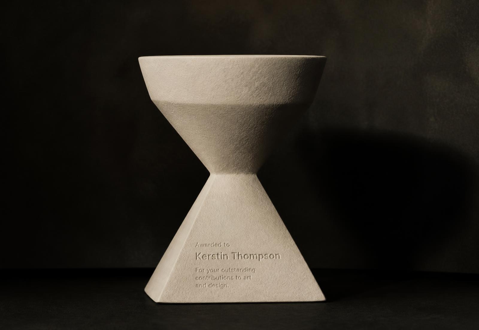 Sculptural cast award object on a dark surface